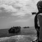 Fulvia, coordinatrice des opérations de sauvetage, donne des instructions aux personnes sur le bateau surchargé, avant de pouvoir distribuer les gilets de sauvetage. Ce jour-là, les équipes de MSF effectueront 6 sauvetages en moins de dix heures, un record. 7 juillet 2022.